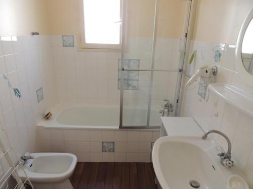 une salle de bain avec un lavabo, une baignoire et des toilettes dans l'établissement Maison Royan 70 m² avec jardin, proche plage et casino, quartier calme - FR-1-71-52, à Royan