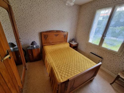 um quarto com uma cama com uma colcha amarela em Maison Royan, 4 pièces, 6 personnes - FR-1-71-52 em Royan