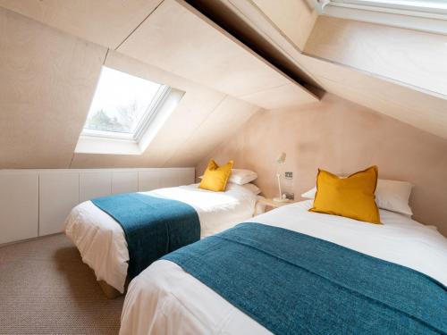 duas camas num quarto com duas janelas em The Joiners Rest em Stowting