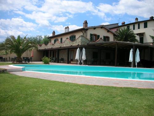 a house with a swimming pool in front of a building at Agriturismo Manetti in Montespertoli