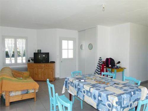 - un salon avec une table, des chaises et une télévision dans l'établissement Maison Familiale à Longeville-sur-Mer, Proche Plage et Commerces, Terrasse et Jardin Clôturé - FR-1-336-78, à Longeville-sur-Mer