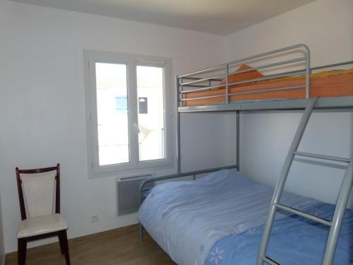 une chambre avec un lit superposé et une chaise dans l'établissement Maison Familiale à Longeville-sur-Mer, Proche Plage et Commerces, Terrasse et Jardin Clôturé - FR-1-336-78, à Longeville-sur-Mer