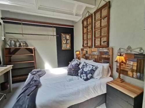 um quarto com uma grande cama branca com almofadas em SomethingElz@Grace em Pretoria