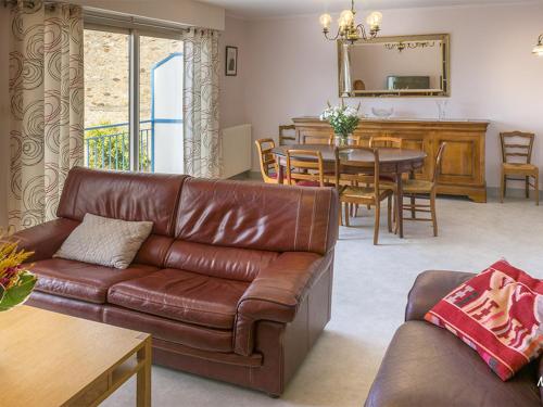 un salon avec un canapé en cuir et une table dans l'établissement Maison de ville 5 chambres à Lorient avec jardinet et garage, proche centre, 10 couchages, WiFi - FR-1-349-152, à Lorient