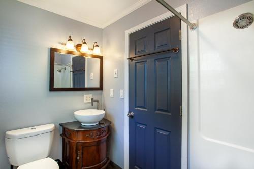 La salle de bains est pourvue d'une porte bleue et d'un lavabo. dans l'établissement Charming Historic Retreat 5 Mins from Downtown, à Knoxville