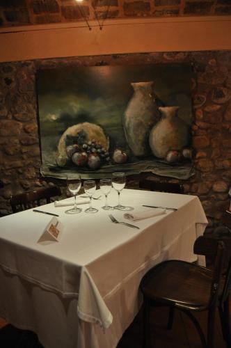a table with wine glasses and a painting on the wall at Hotel Masia La Palma in Espinavesa