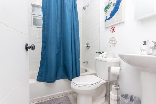 een badkamer met een toilet en een blauw douchegordijn bij Home Miami - Wynwood area with backyard - Art District near to Beach in Miami