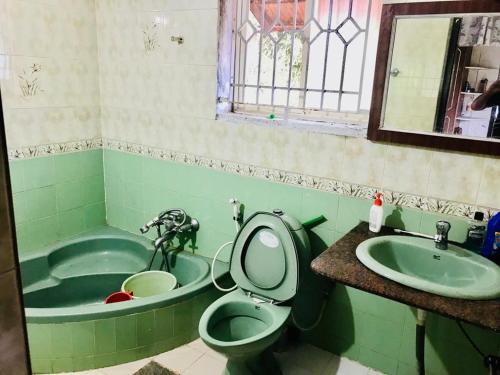a bathroom with a sink and a toilet and a tub at La Paz Coorg homestay at Madikeri town in Madikeri