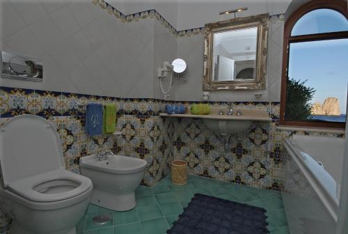a bathroom with a toilet and a sink and a mirror at Diva La Canzone Del Mare in Capri