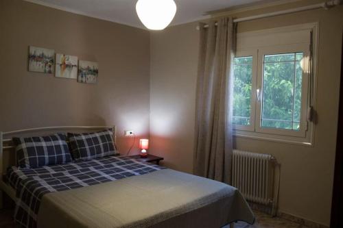 1 dormitorio con cama y ventana en Veria Ammos apartment to farm with treehouse en Ámmos