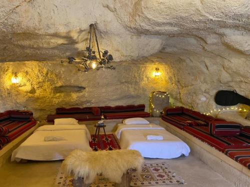 a room with four beds in a cave at 7 Caves Hotel in Al Jāyah