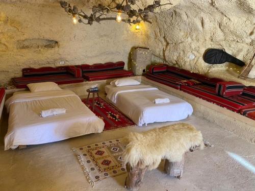a room with two beds in a stone room at 7 Caves Hotel in Al Jāyah