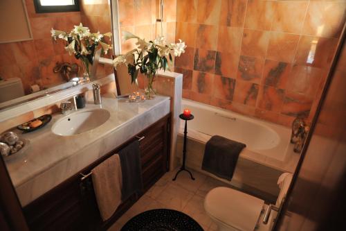 a bathroom with a sink and a tub with flowers at Villa Calero in Playa Blanca