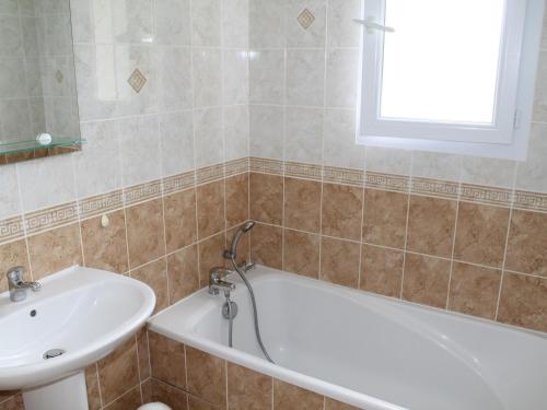 a bathroom with a bath tub and a sink at Maison avec Jardin proche Thermes comprenant Lave-linge et Lave-vaisselle - FR-1-541-47 in La Roche-Posay