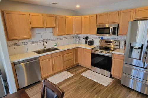 a kitchen with wooden cabinets and stainless steel appliances at 3 bed 2.5 bath smart home with rv parking in Casper