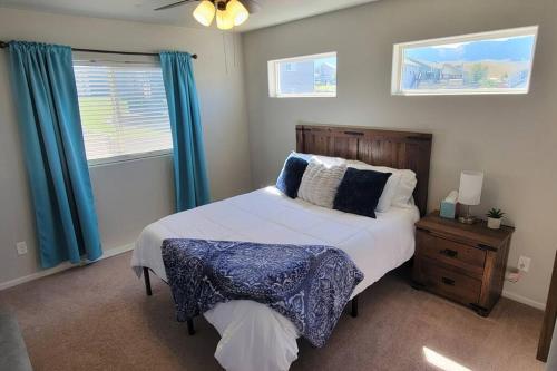 a bedroom with a large bed with blue curtains at 3 bed 2.5 bath smart home with rv parking in Casper
