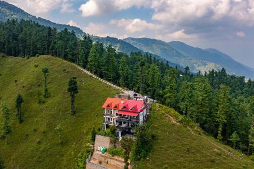 a house on a hill with a red roof at Eastbury by VEO - Part of StayVista in Mashobra