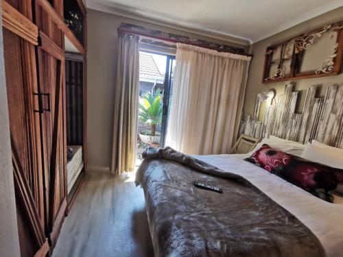 a bedroom with a large bed and a large window at SomethingElz@Grace in Pretoria