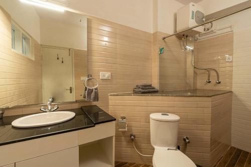 a bathroom with a toilet and a sink at StayVista at Eastbury in Mashobra