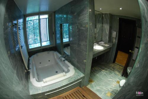 a large bathroom with a tub and a sink at Massabki Hotel in Chtaura