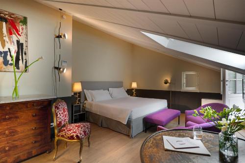 a hotel room with a bed and a table and chairs at Maison Borella in Milan