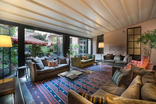 a living room with couches and tables and windows at Maison Borella in Milan