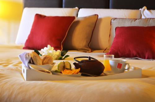a tray of food on a bed with drinks and snacks at Ayres del Champaqui Hotel Boutique Experiencial & Spa in Villa General Belgrano