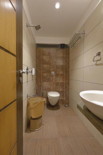 a bathroom with a toilet and a sink at Hotel Ariana Residency in Mumbai