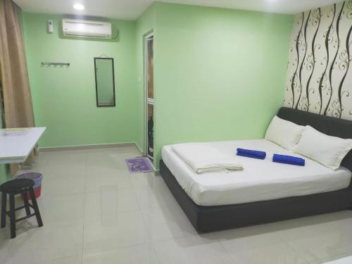 a small room with a bed and a table and a desk at Leaf Guest House in Kuantan
