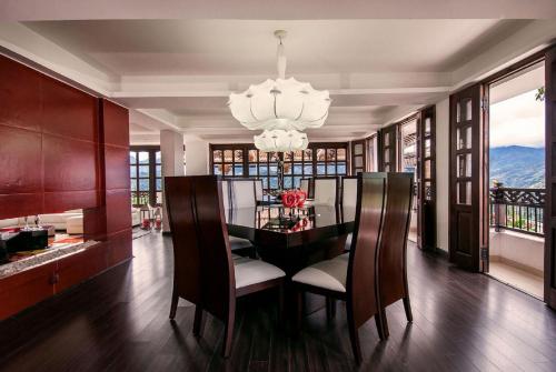une salle à manger avec une table, des chaises et un lustre dans l'établissement Hotel Reserva Monarca, à Salento