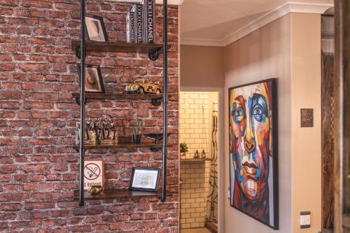 a room with a brick wall with shelves at TnT on Main in Hermanus