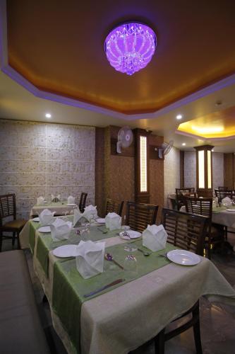 a dining room with a long table with a purple chandelier at Rock Castle By DLS Hotels in Shimla