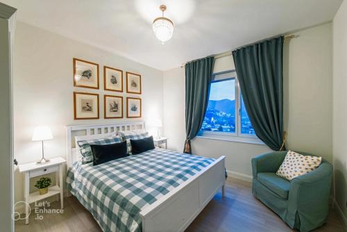 a bedroom with a bed and a chair and a window at Lakeview Panorama Penthouse with Washer & Dryer in Lugano