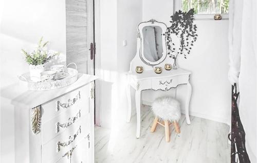 a white dressing table with a mirror and a stool at Lovely Home In Sulnowo With Lake View in Smetowo Graniczne
