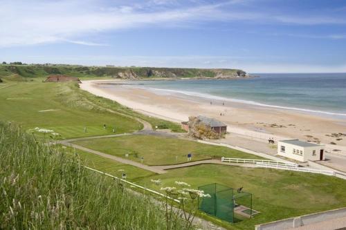 a view of a beach with a building and the ocean at Palace Hotel in Peterhead