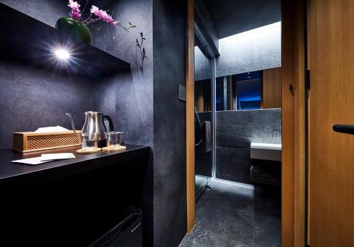 baño con lavabo y encimera con espejo en HOTEL和紡 en Nagoya