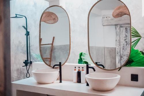 a bathroom with two sinks and two mirrors at VILLA LA ISLA BONITA walking distance to the beach in Gili Air