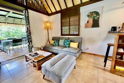 uma sala de estar com um sofá e uma mesa em Fare Auti - halfway beach and mountain on Moorea em Haapiti