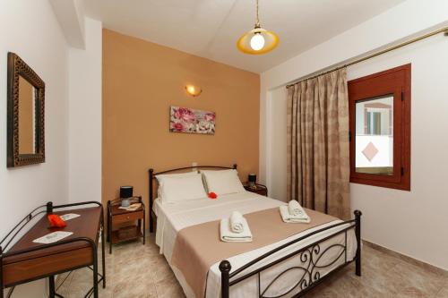 ein Hotelzimmer mit einem Bett und einem Tisch in der Unterkunft Hara's Apartments in Kastrí