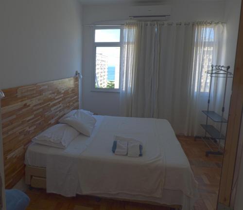 a bedroom with a white bed and a window at Copacabana wonderful apartment in Rio de Janeiro