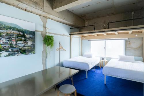 een kamer met 2 bedden, een bureau en een raam bij RE SORT in Sasebo