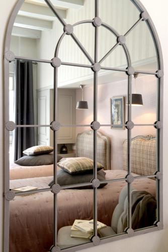 a mirror in a bedroom with two beds at Hôtel Saint Pierre Boutique-Hôtel in Saumur
