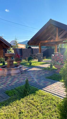 a garden with a wooden pavilion and a patio at Hostynnyy Dvir Apartament Hotel & SPA in Slavske