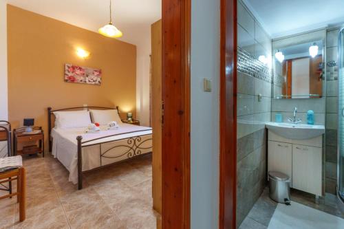 1 dormitorio con cama, ducha y lavamanos en Hara's Apartments, en Kastrí
