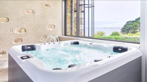 una vasca da bagno in una stanza con finestra di Pavillon de la plage a Trébeurden