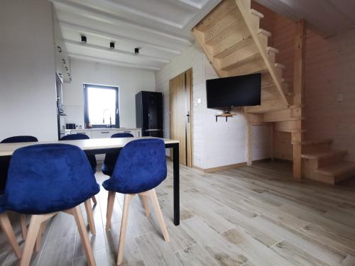 a room with a table and two blue chairs at Domki całoroczne Joni in Sarbinowo