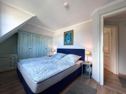 Schlafzimmer mit einem Bett mit blauem Kopfteil in der Unterkunft Meer-Lust-Sylt sea cottage in Westerland