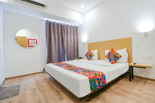 ein Schlafzimmer mit einem großen weißen Bett und einem Tisch in der Unterkunft FabHotel Destiny Inn in Gurgaon