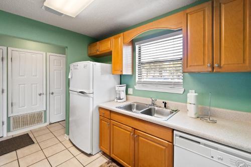 a kitchen with a white refrigerator and a sink at Sugar Beach D17 in Navarre