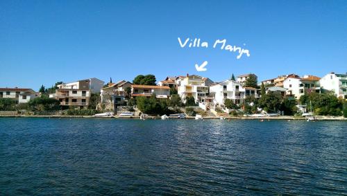 ピロヴァッツにあるVilla Manjaの家屋とコンドミニアムのある湖の景色
